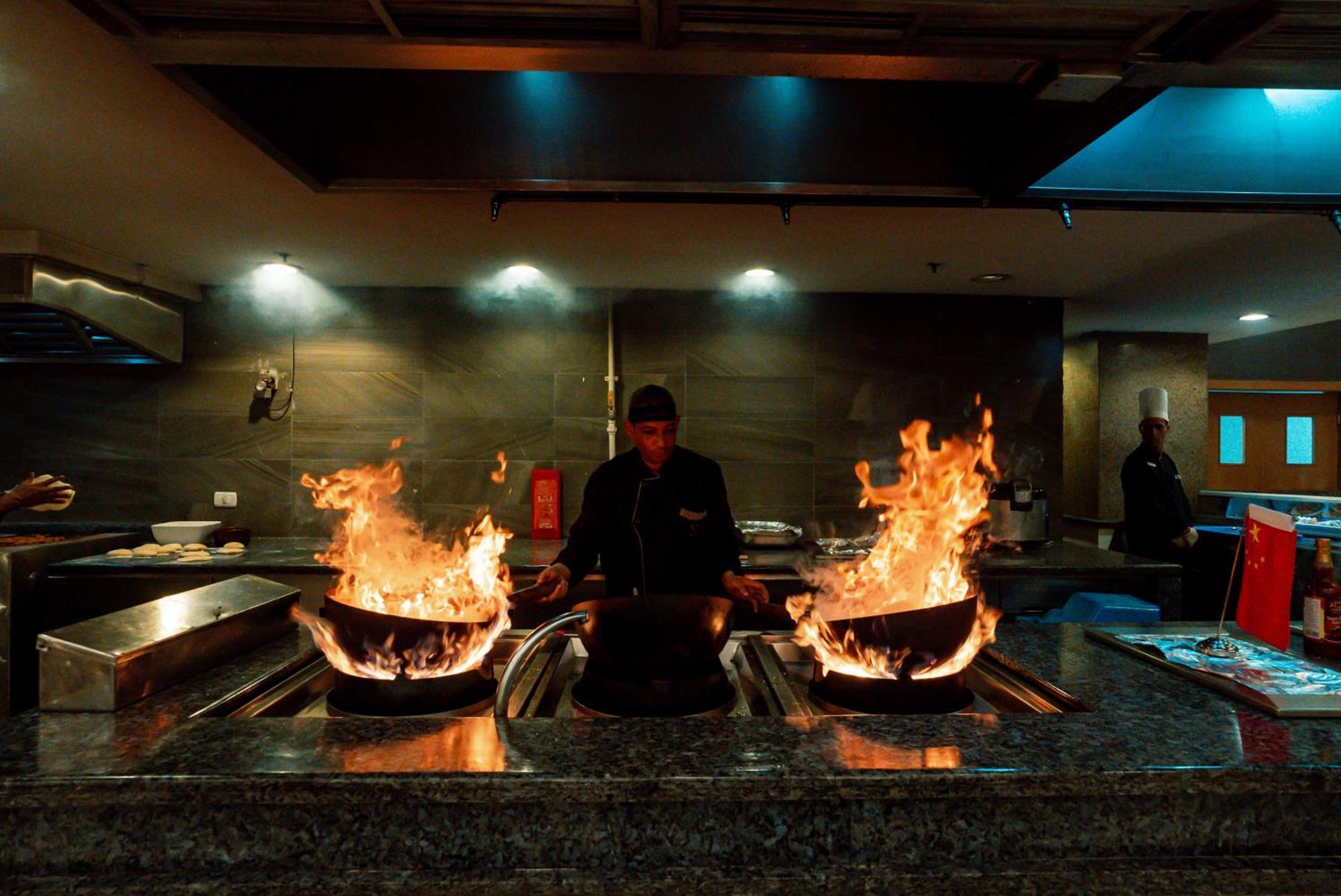 The V Luxury Resort Sahl Hasheesh ฮูร์กาดา ภายนอก รูปภาพ A chef cooking with a wok