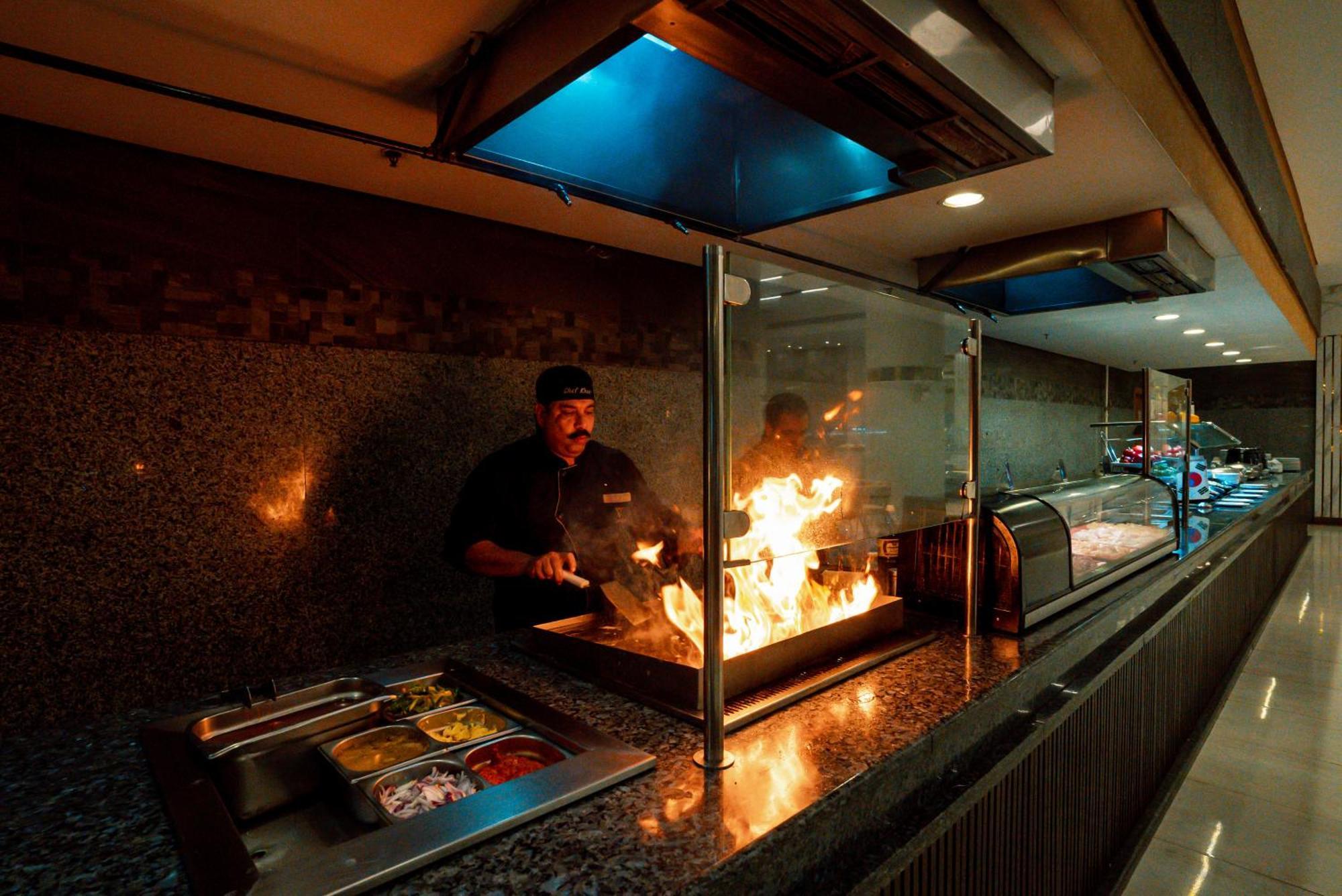 The V Luxury Resort Sahl Hasheesh ฮูร์กาดา ภายนอก รูปภาพ A chef cooking with a flaming torch