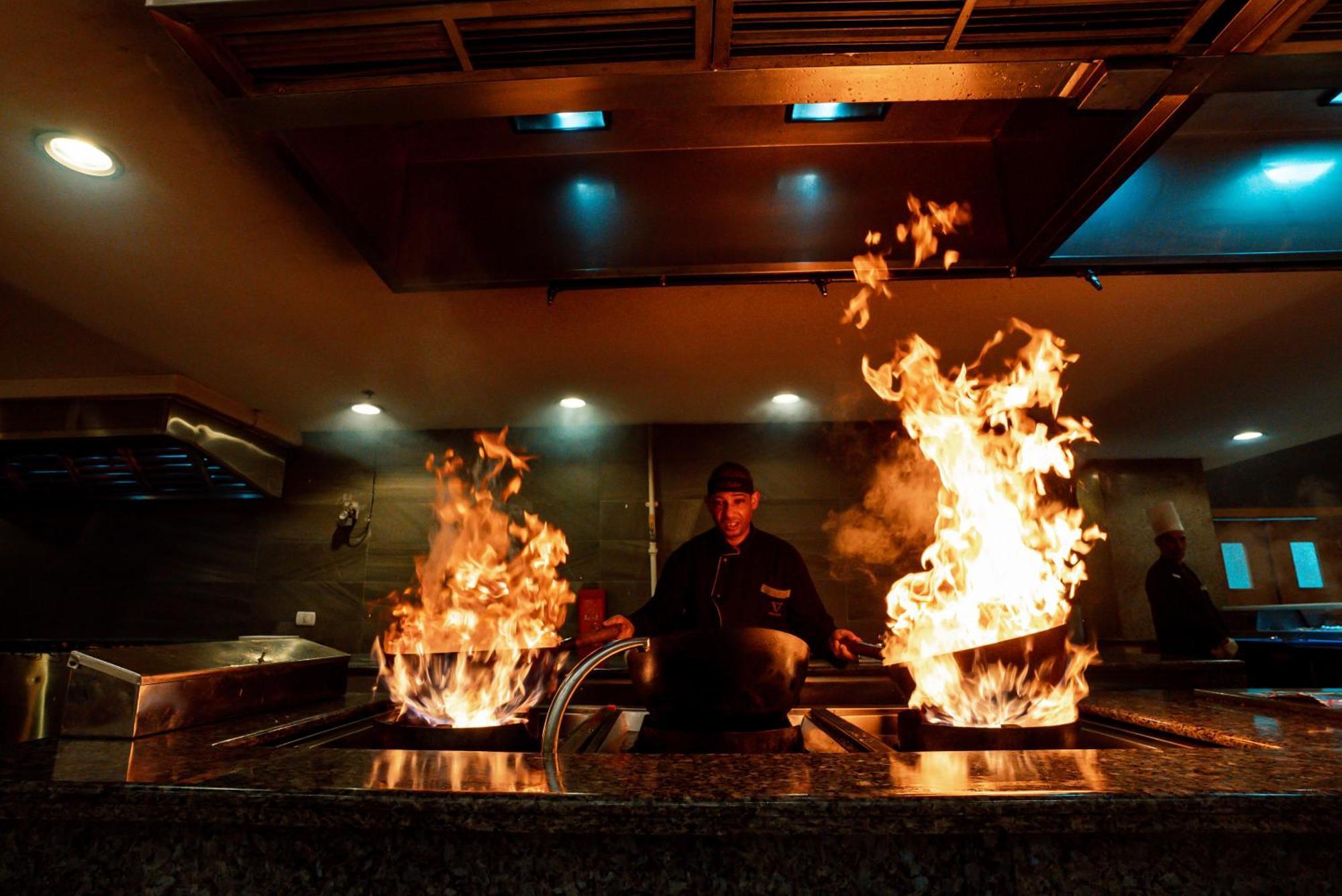 The V Luxury Resort Sahl Hasheesh ฮูร์กาดา ภายนอก รูปภาพ A chef cooking with a wok