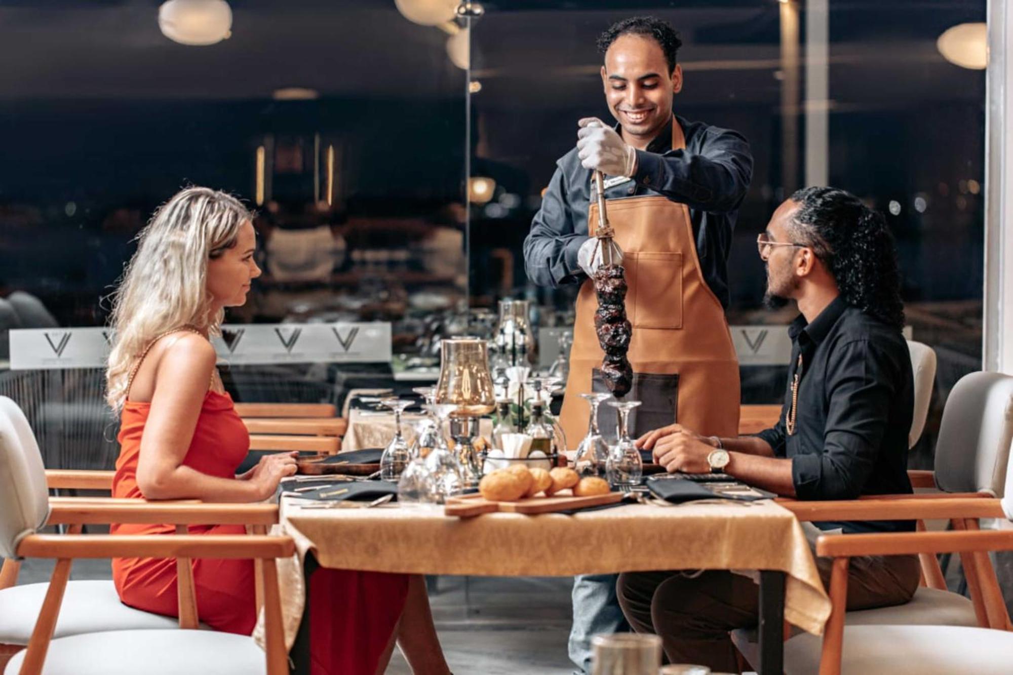 The V Luxury Resort Sahl Hasheesh ฮูร์กาดา ภายนอก รูปภาพ A waiter serving a couple at a restaurant